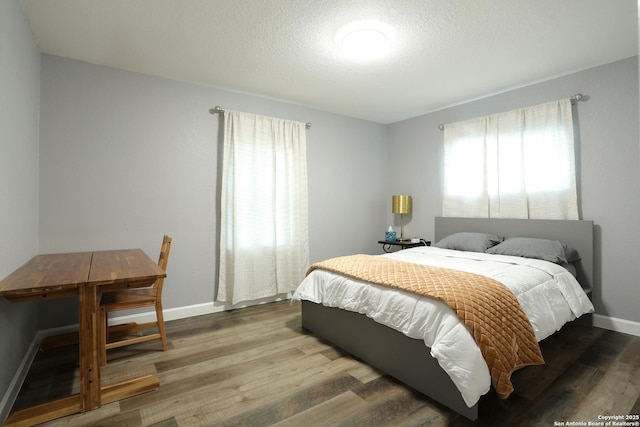 bedroom with wood-type flooring and a textured ceiling