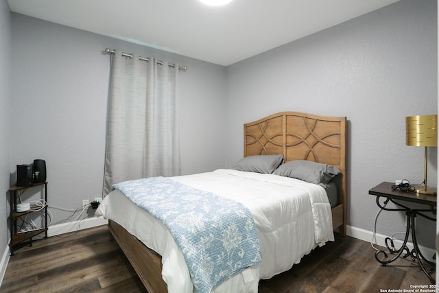 bedroom with dark hardwood / wood-style floors