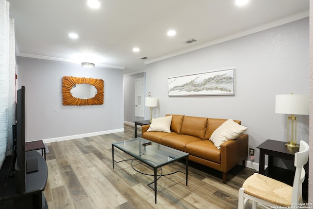 living room with wood-type flooring and ornamental molding