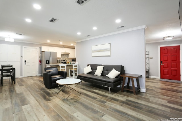 living room with hardwood / wood-style floors and crown molding