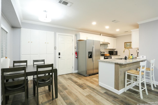 kitchen featuring white cabinetry, sink, stainless steel appliances, kitchen peninsula, and ornamental molding