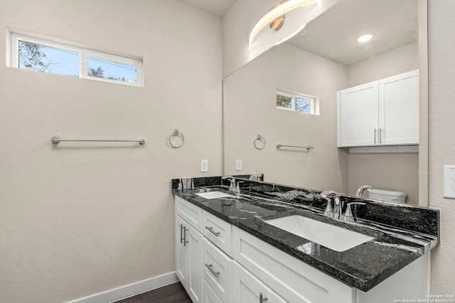 bathroom featuring vanity, hardwood / wood-style flooring, toilet, and plenty of natural light