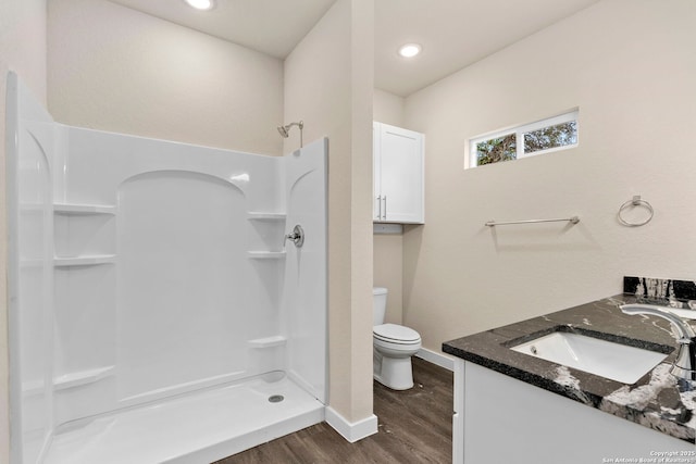 bathroom featuring walk in shower, hardwood / wood-style floors, vanity, and toilet