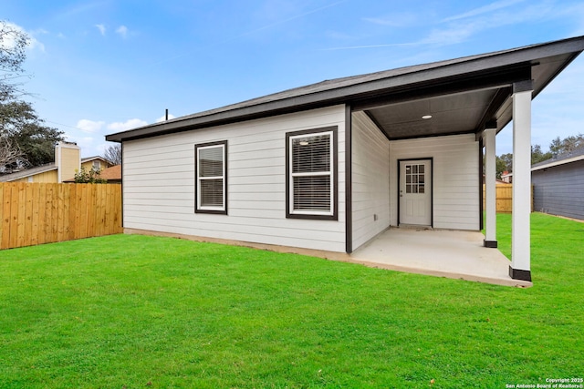 rear view of property with a lawn and a patio