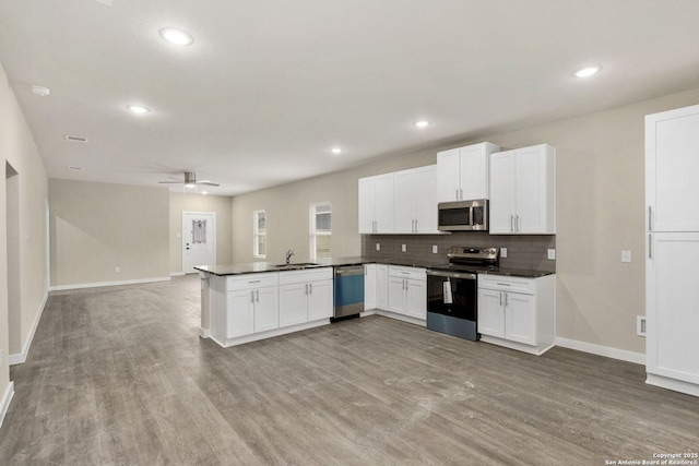 kitchen featuring white cabinets, kitchen peninsula, and appliances with stainless steel finishes