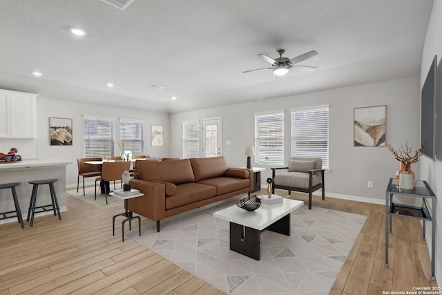 living room featuring ceiling fan and light hardwood / wood-style floors