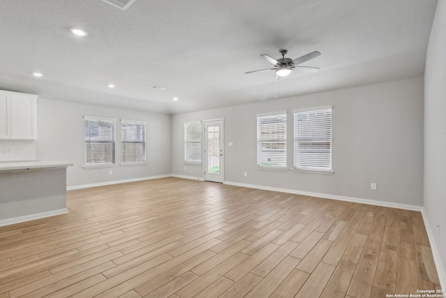 unfurnished living room featuring ceiling fan and light wood-type flooring