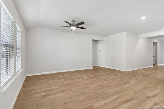 unfurnished room with ceiling fan, vaulted ceiling, and light wood-type flooring