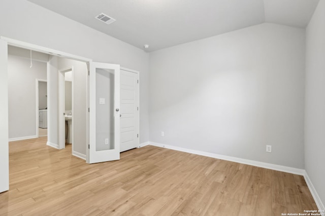 unfurnished bedroom featuring a closet, lofted ceiling, and light wood-type flooring