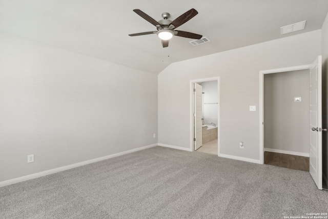 unfurnished bedroom featuring ceiling fan, lofted ceiling, light carpet, and connected bathroom