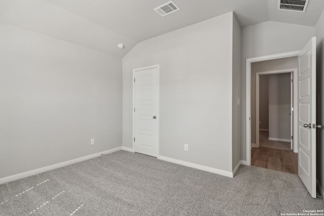 unfurnished bedroom with lofted ceiling and carpet floors