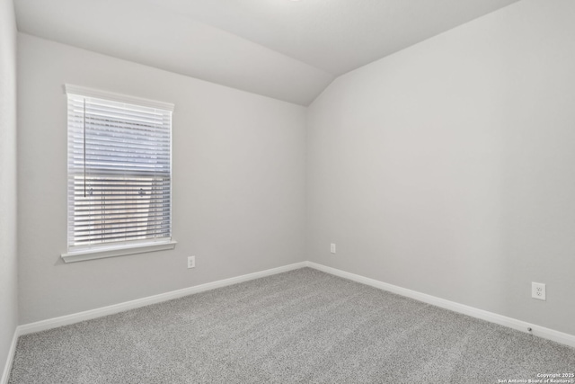 empty room with carpet, a healthy amount of sunlight, and vaulted ceiling