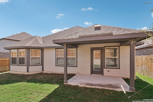 rear view of property featuring a yard and a patio