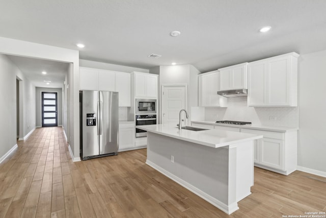 kitchen featuring white cabinets, appliances with stainless steel finishes, backsplash, and sink