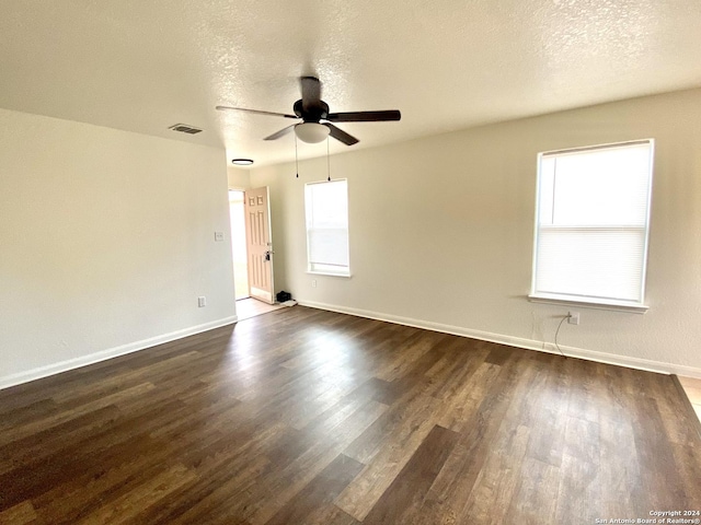 empty room featuring ceiling fan, a textured ceiling, and dark wood-type flooring