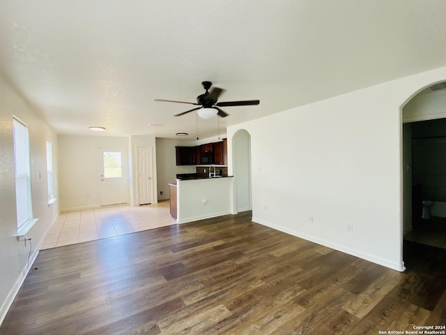 unfurnished living room with ceiling fan and wood-type flooring