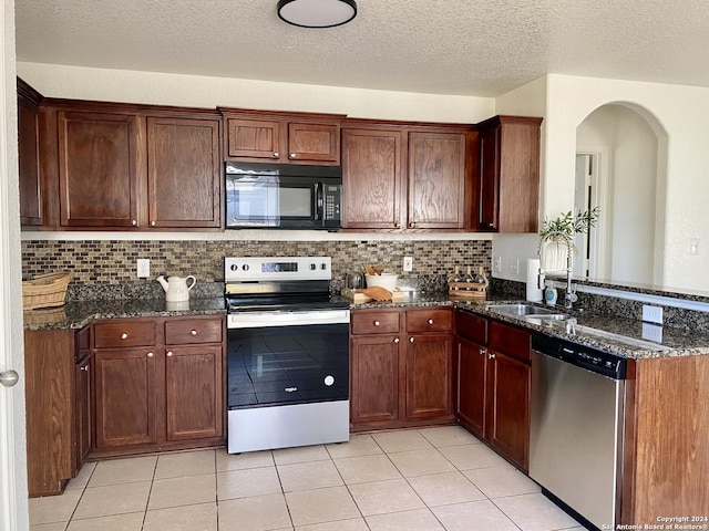 kitchen featuring range with electric cooktop, tasteful backsplash, dark stone counters, sink, and dishwasher