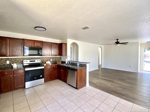 kitchen with range with electric cooktop, ceiling fan, stainless steel dishwasher, kitchen peninsula, and decorative backsplash