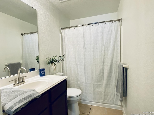 bathroom with tile patterned floors, vanity, a textured ceiling, and toilet