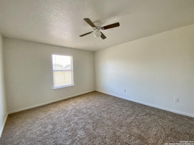 spare room featuring ceiling fan and carpet