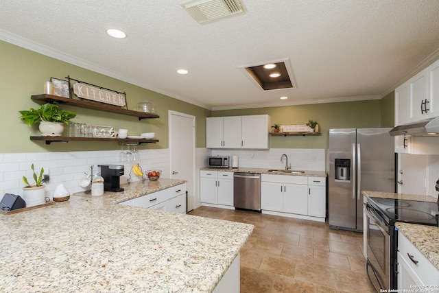 kitchen with white cabinetry, sink, light stone counters, a textured ceiling, and appliances with stainless steel finishes