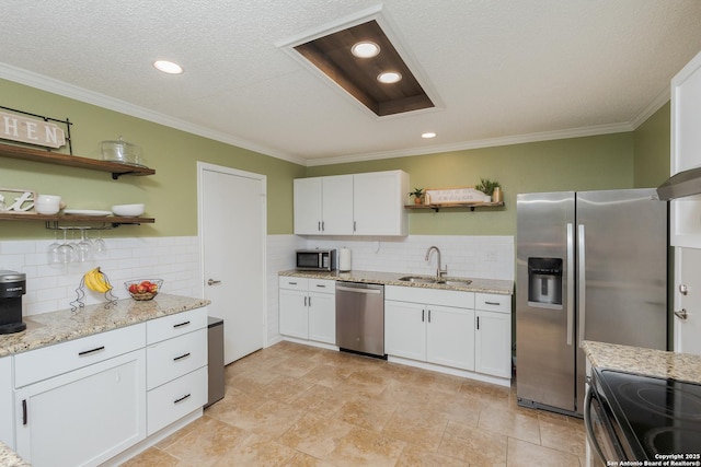 kitchen featuring white cabinets, stainless steel appliances, light stone counters, and sink