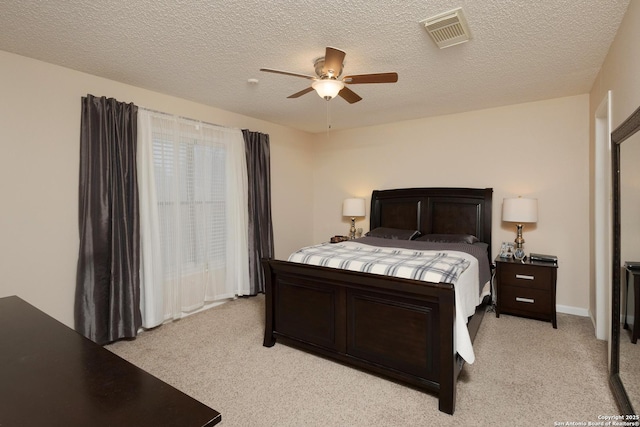 bedroom featuring light carpet, a textured ceiling, and ceiling fan