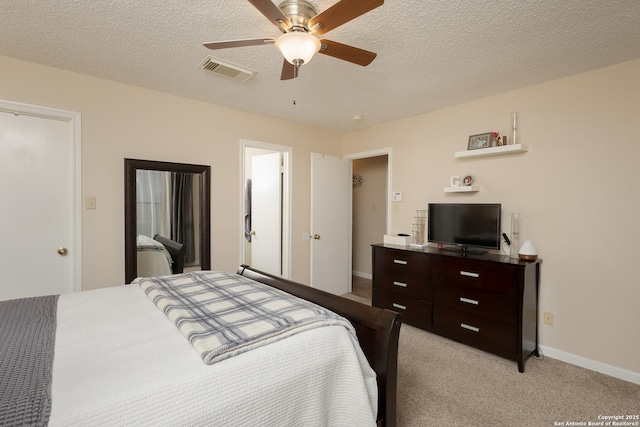 bedroom featuring a textured ceiling, ceiling fan, and light carpet