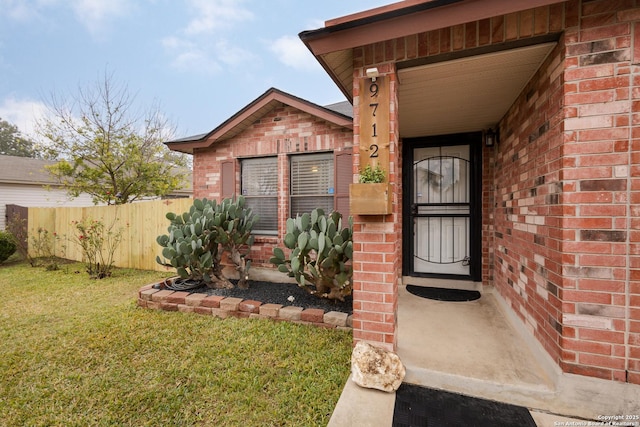 entrance to property with a lawn