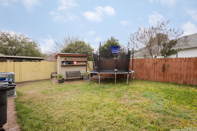 view of yard with central air condition unit and a trampoline