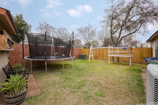 view of yard with a trampoline and central AC unit