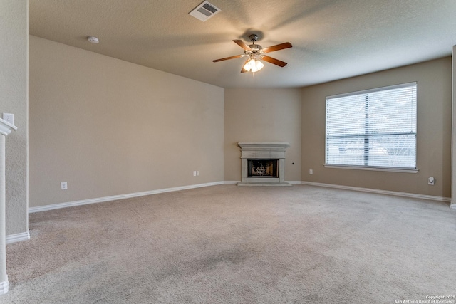 unfurnished living room with light carpet, a textured ceiling, and ceiling fan