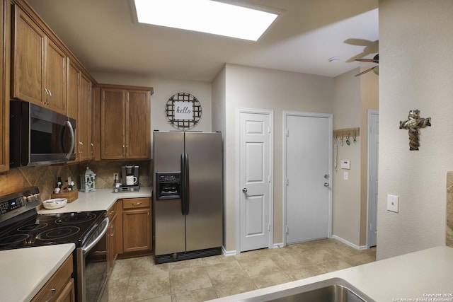 kitchen featuring decorative backsplash, ceiling fan, and stainless steel appliances