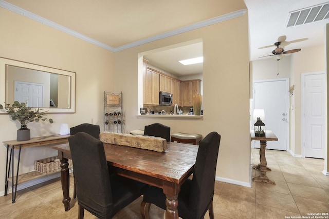 dining room with light tile patterned floors, ceiling fan, ornamental molding, and sink