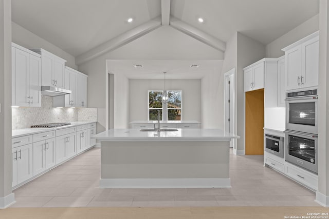 kitchen featuring white cabinetry, appliances with stainless steel finishes, a kitchen island with sink, and sink