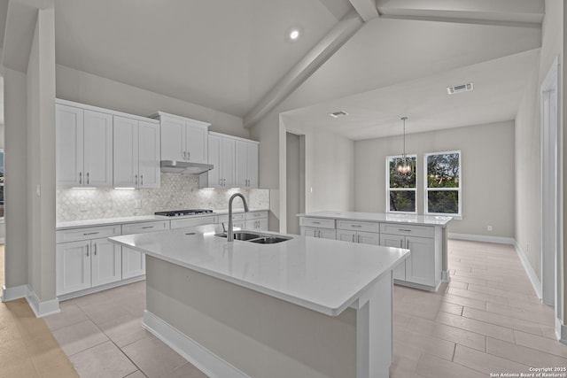 kitchen featuring sink, an island with sink, white cabinets, and stainless steel gas cooktop