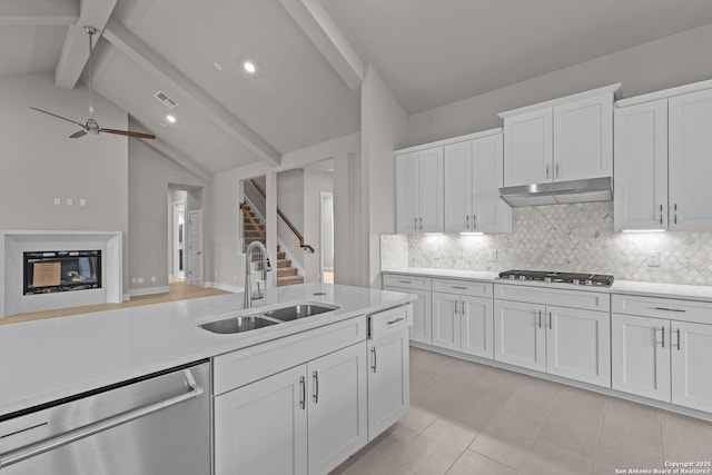 kitchen featuring sink, white cabinetry, backsplash, stainless steel appliances, and lofted ceiling with beams