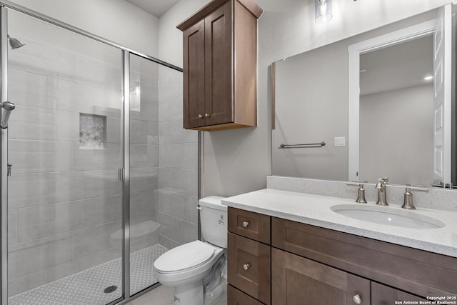 bathroom with vanity, toilet, and a shower with door