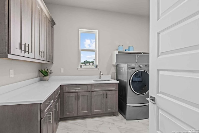 washroom with sink, washer / clothes dryer, and cabinets