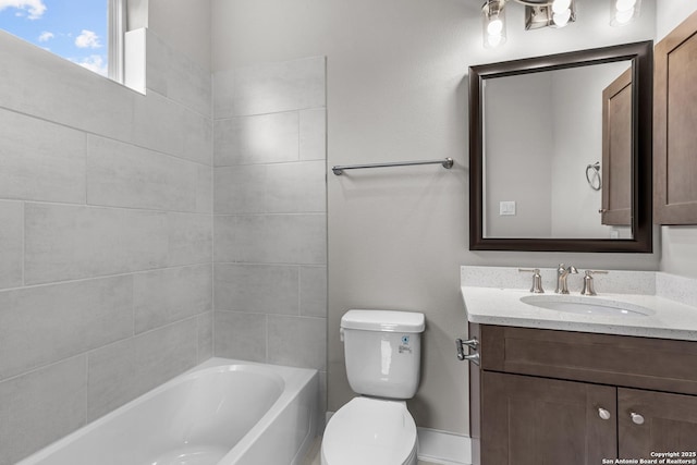 full bathroom with vanity, tiled shower / bath, and toilet