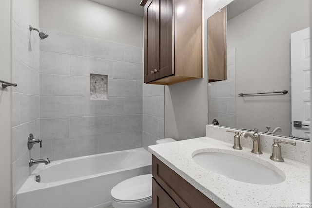 full bathroom featuring tiled shower / bath combo, vanity, and toilet