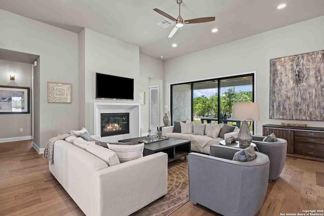 living room with light hardwood / wood-style floors and ceiling fan