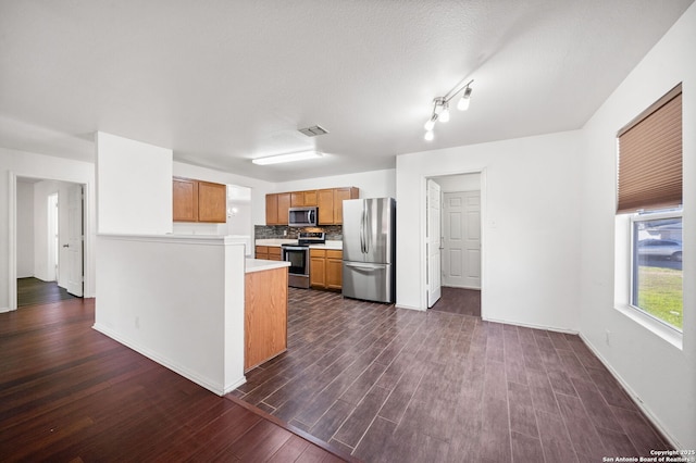 kitchen with backsplash, dark hardwood / wood-style floors, and appliances with stainless steel finishes