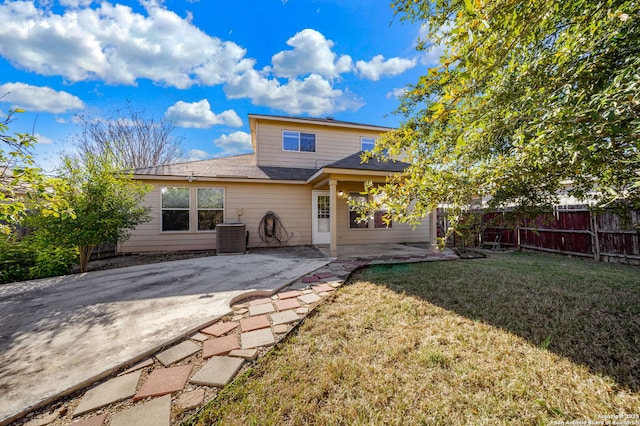 back of property with central AC unit, a yard, and a patio