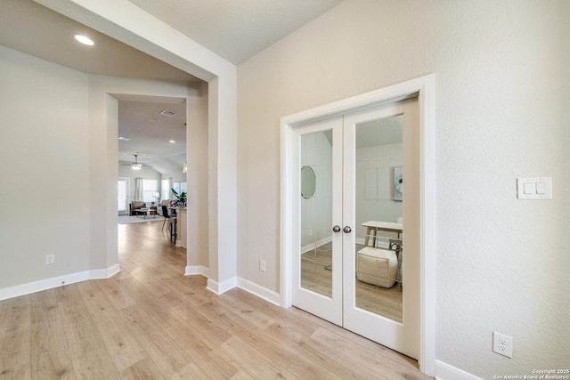 corridor featuring light wood-type flooring and french doors