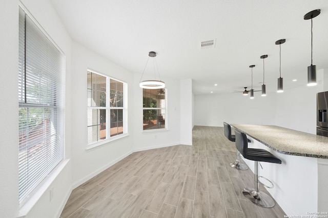 unfurnished dining area featuring light hardwood / wood-style floors and ceiling fan