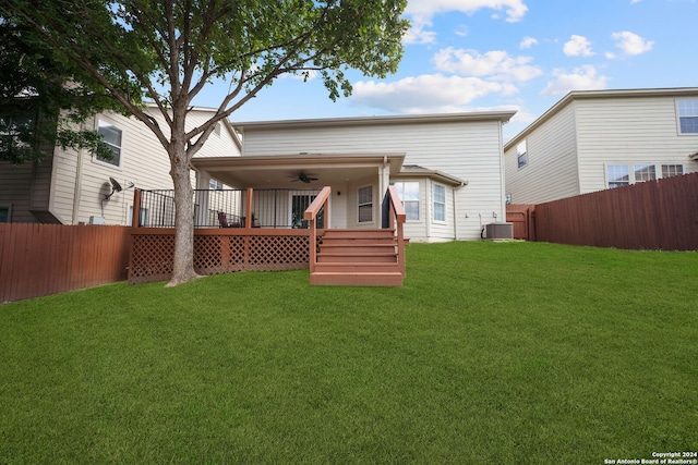 back of property with ceiling fan, central air condition unit, a wooden deck, and a yard