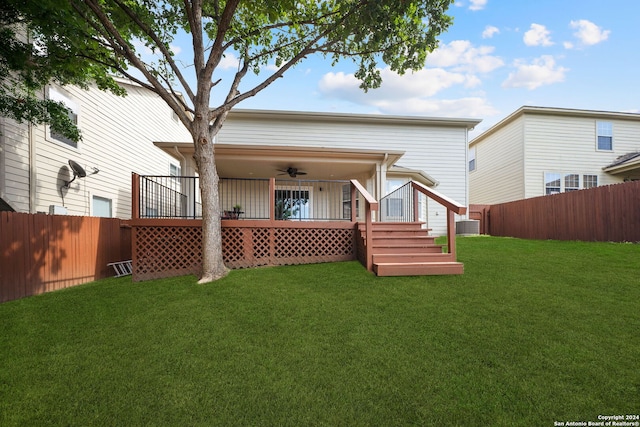 rear view of house with ceiling fan, central AC unit, and a yard