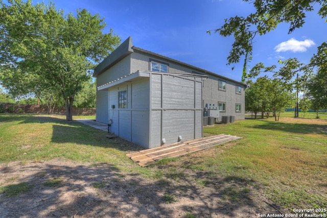 view of property exterior with a lawn and cooling unit