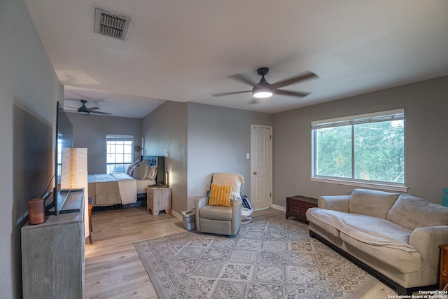 living room featuring ceiling fan and light hardwood / wood-style flooring